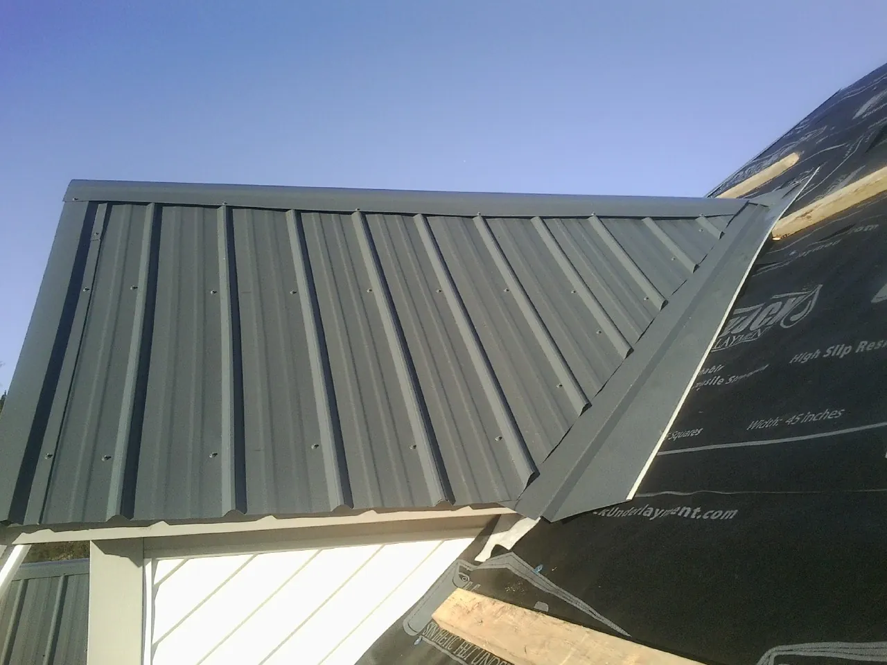 Gray metal roof panels going on over a garage gable in Mundelein