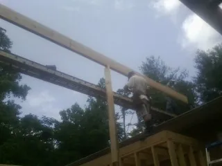 Carpenter setting a ridge beam over a new addition frame — Ice Dam Removal by Roofing Brothers in Mundelein