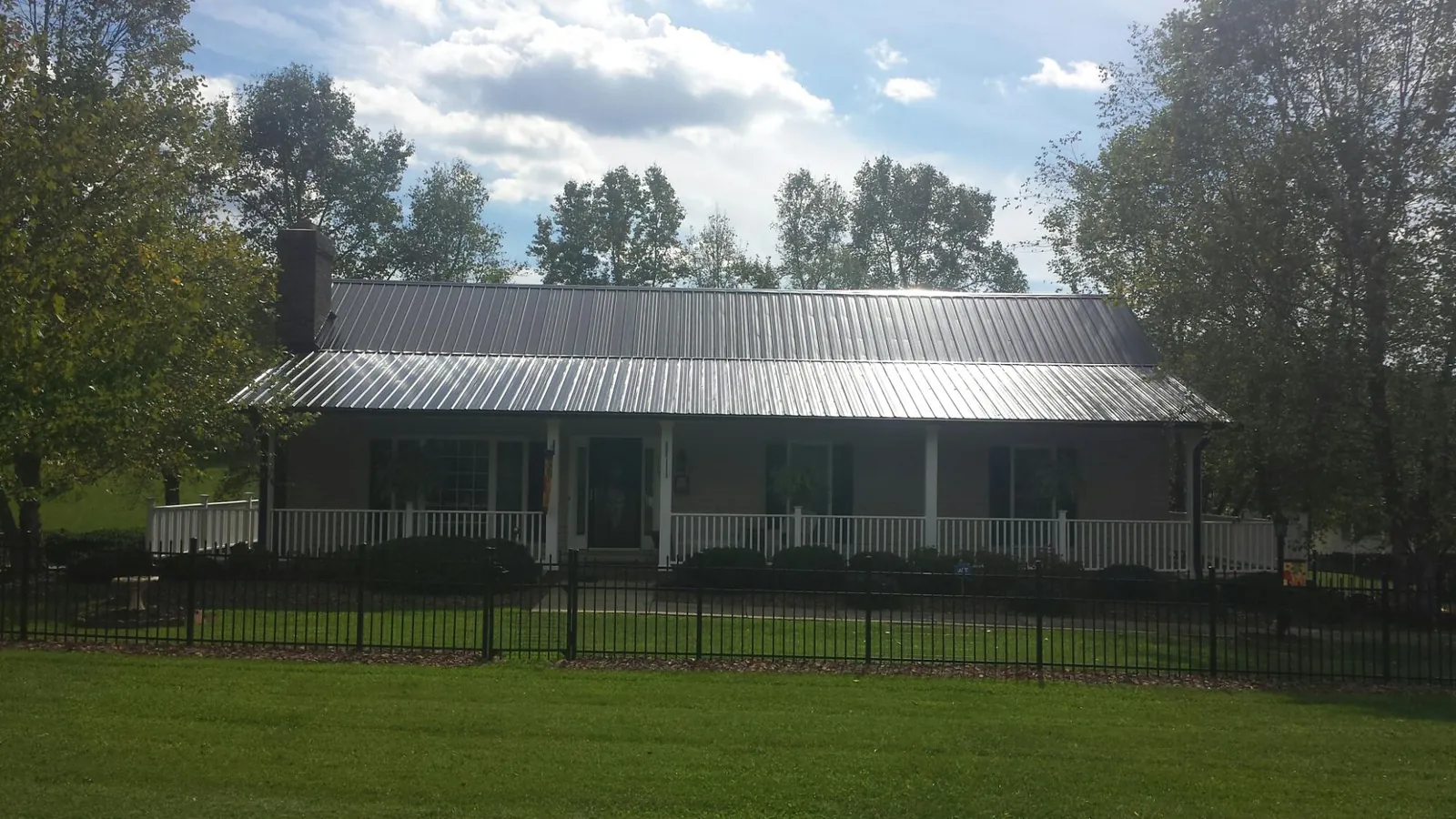 Gray metal roof on a brick ranch with a full width front porch — Gutter Guard Installation work by our crew in Mundelein