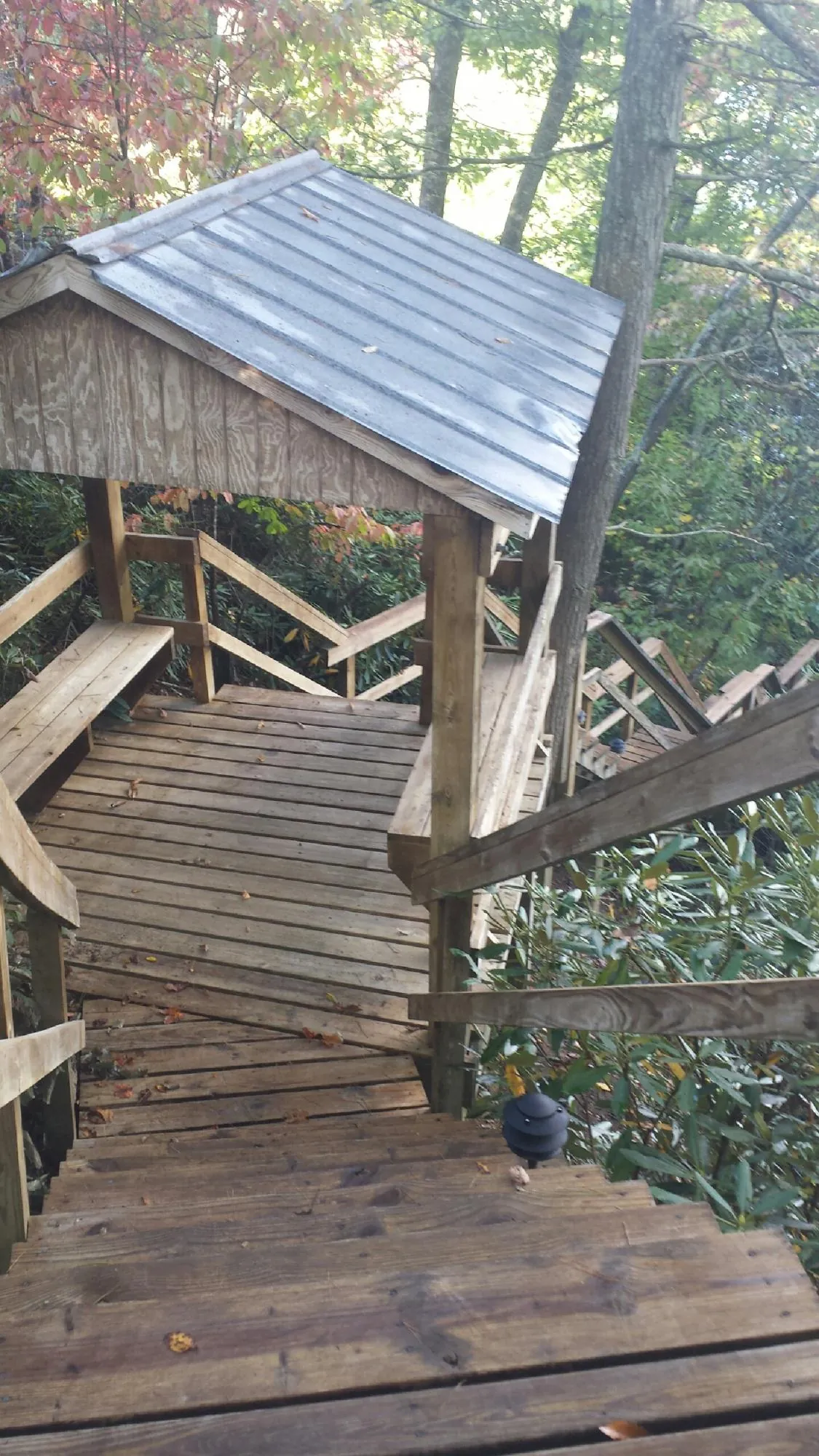 Metal roofed shelter over wooden steps on a wooded walkway — Skylight Repair & Installation work by our crew in Mundelein