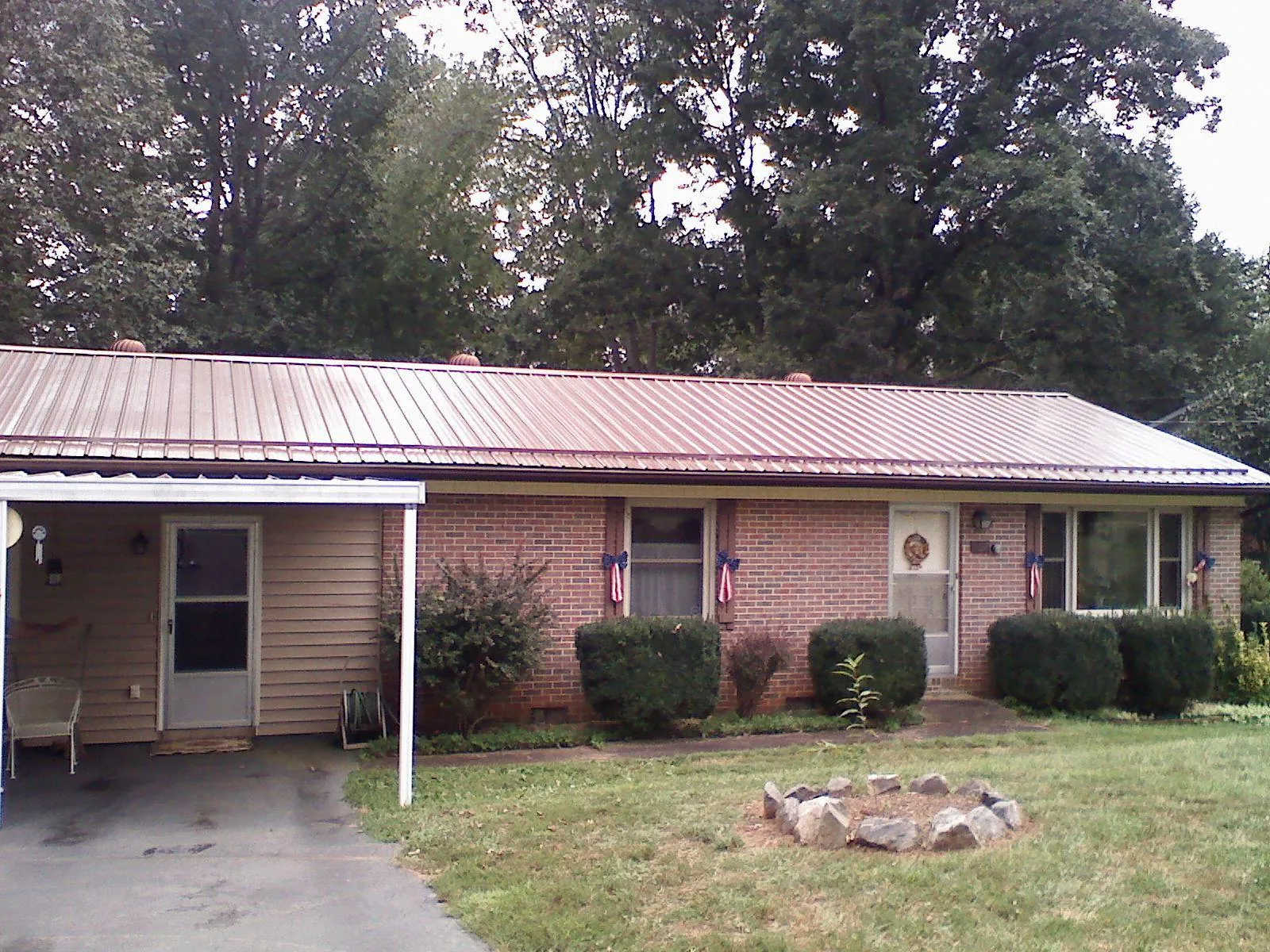 Bronze metal roof and carport on a brick ranch home — Roof Repair work by our crew in Mundelein
